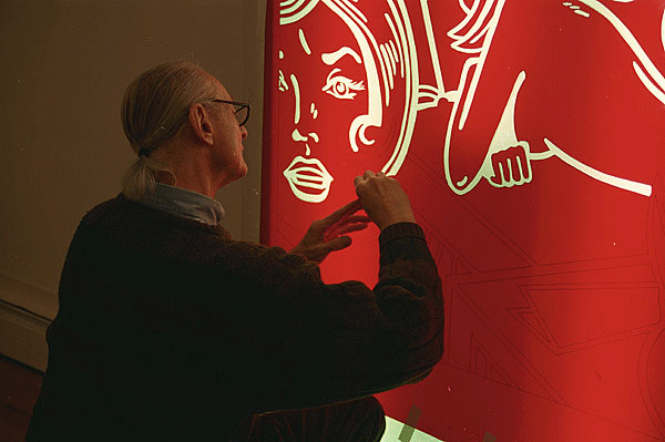Roy Lichtenstein using a light box to cut a Rubylith stencil for his color relief print Roommates, from the Nudes Series, Tyler Graphics Ltd. artist' studio, Mount Kisco, New York, 1994. Photograph by Kenneth Tyler.